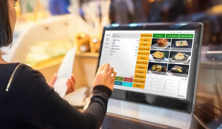 A person uses a touchscreen point of sale system at a restaurant, navigating menu options for food and beverages.