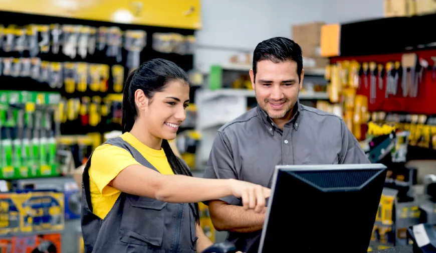 Two store employees using a point of sale system in a hardware store.